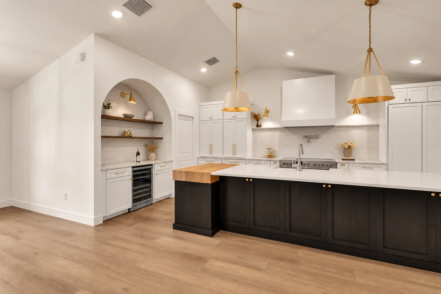 Modern kitchen remodel in Tampa, FL with dark island and arched bar nook