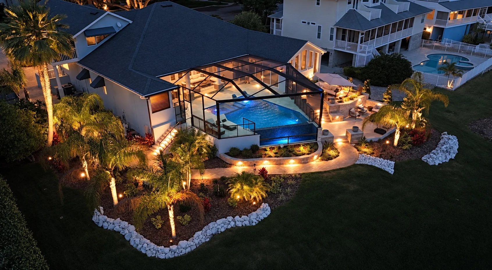 Aerial view of backyard pool and screened lanai in Tampa, FL at dusk