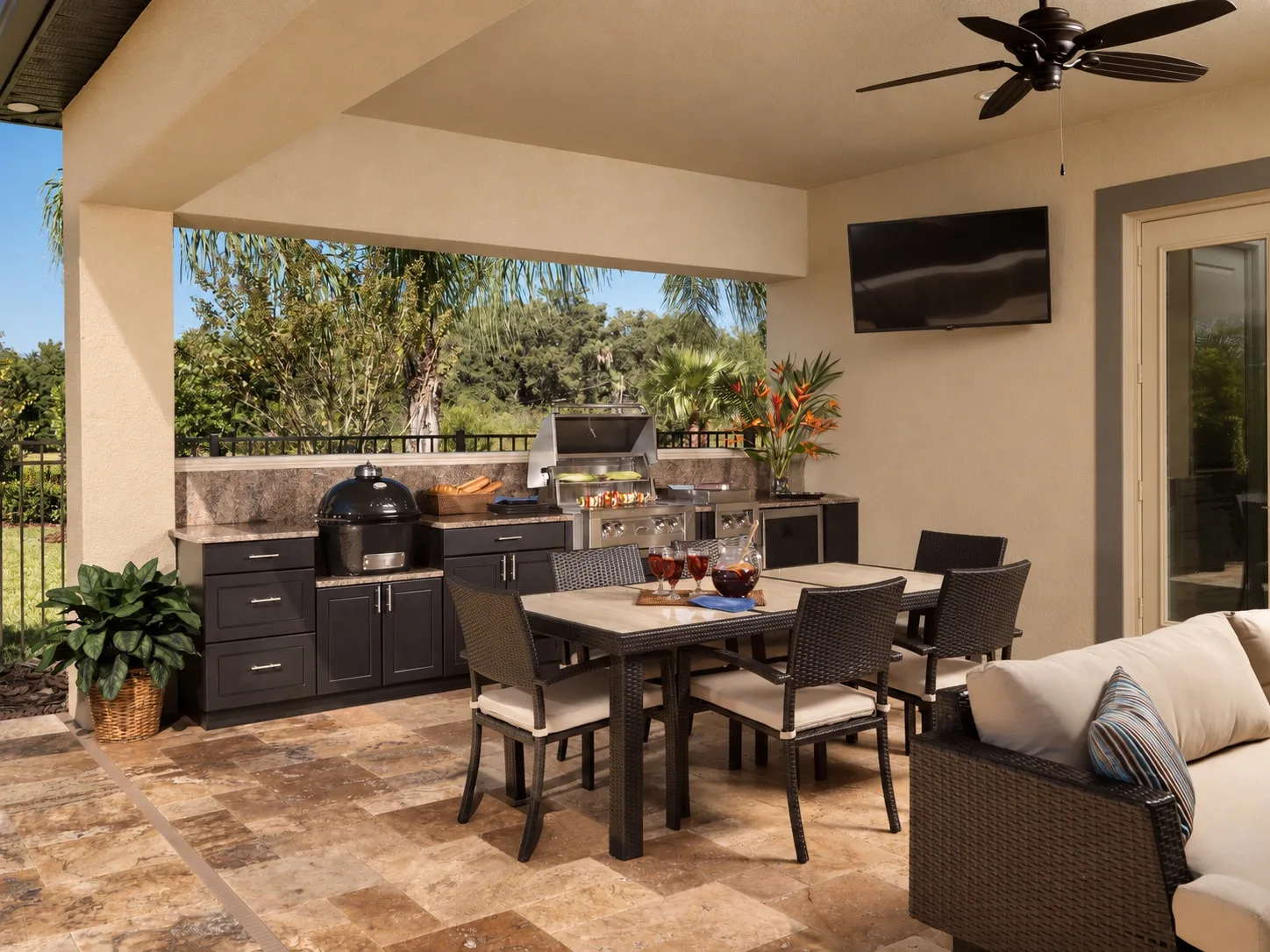 Outdoor kitchen under a covered patio in Tampa, FL with grill and dining area