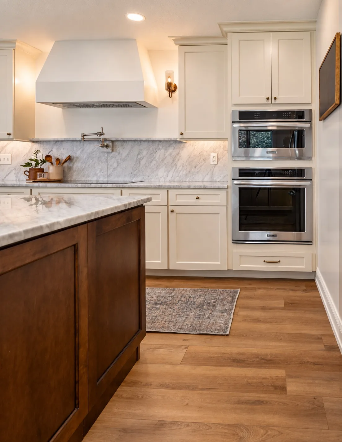 Kitchen remodel in Tampa, FL with white cabinets, marble countertops, and double oven