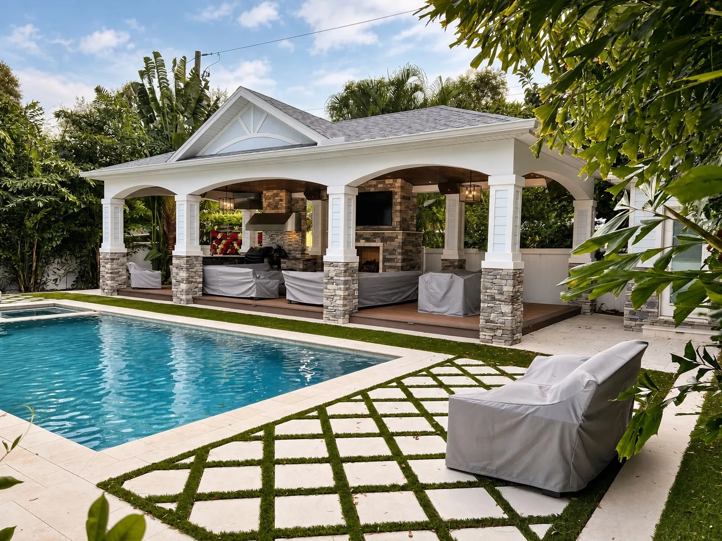 Outdoor pavilion in Tampa, FL with poolside fireplace and living area