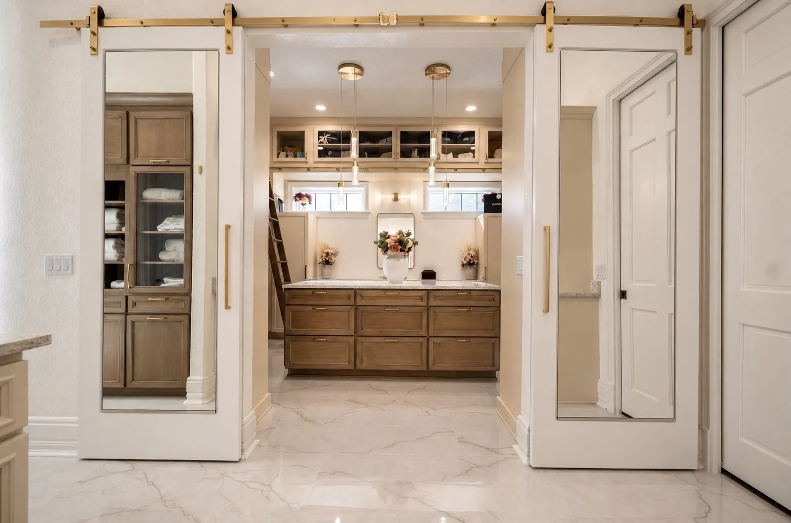 Primary closet entry in Tampa, FL with mirrored sliding barn doors on brass hardware