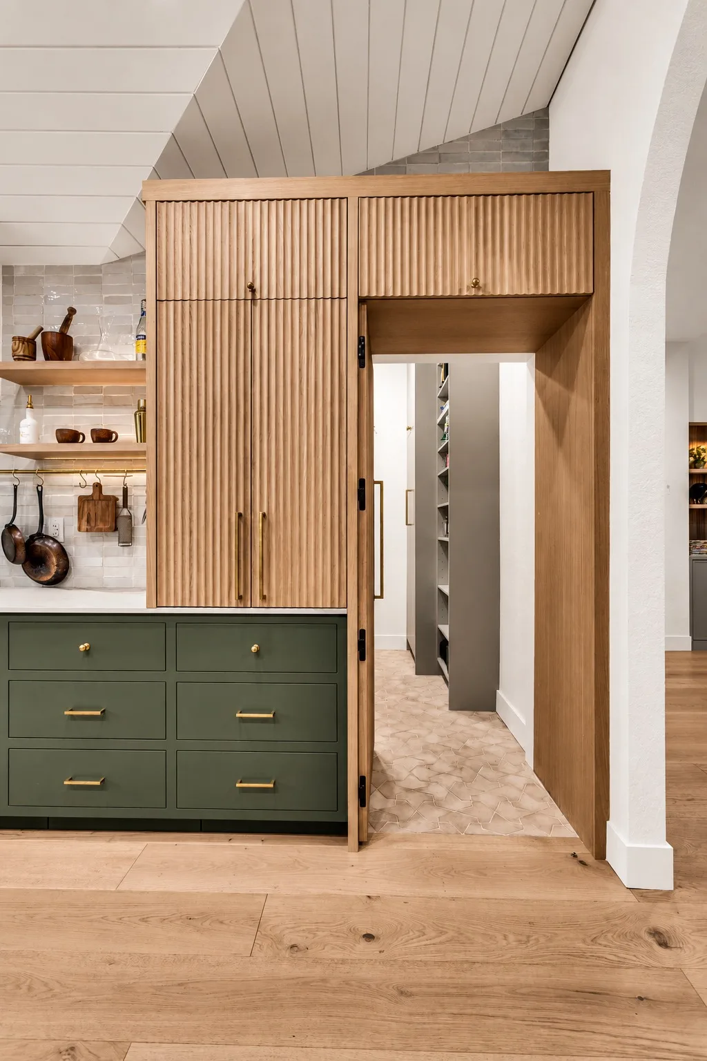 Hidden pantry in Tampa, FL with green cabinets and wood paneling
